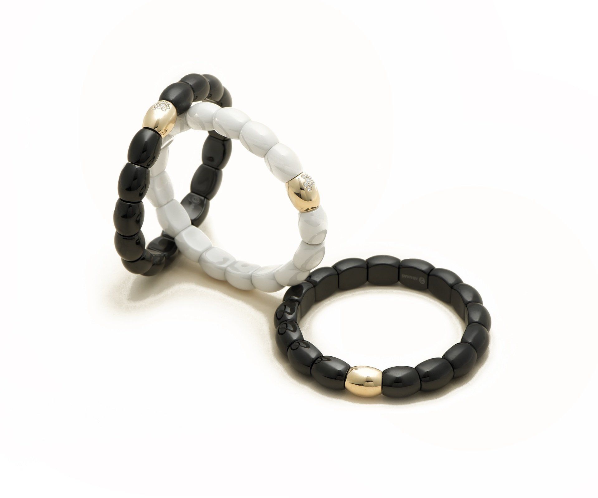 A diamond bangle resting against a strand of cream beads