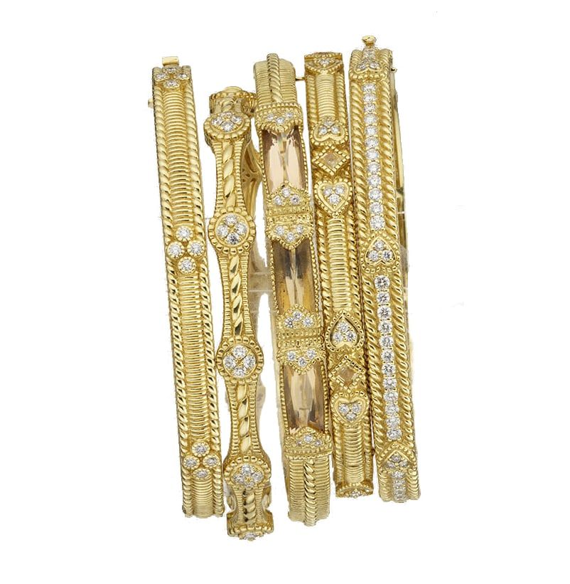 A stack of yellow gold bangles with diamond accents