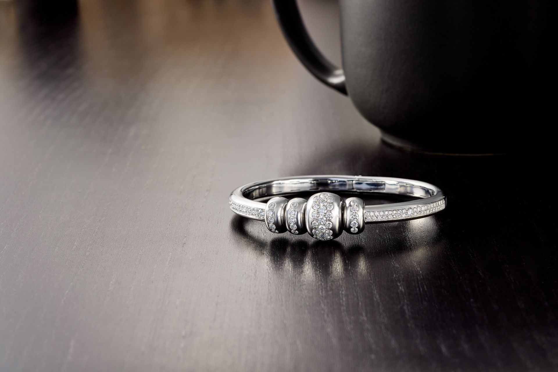 A hammered gold cuff set with diamond flowers