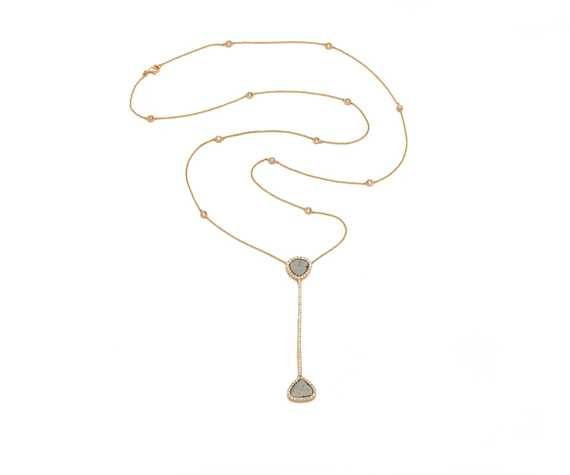 A long gold chain with a pavé diamond disc pendant