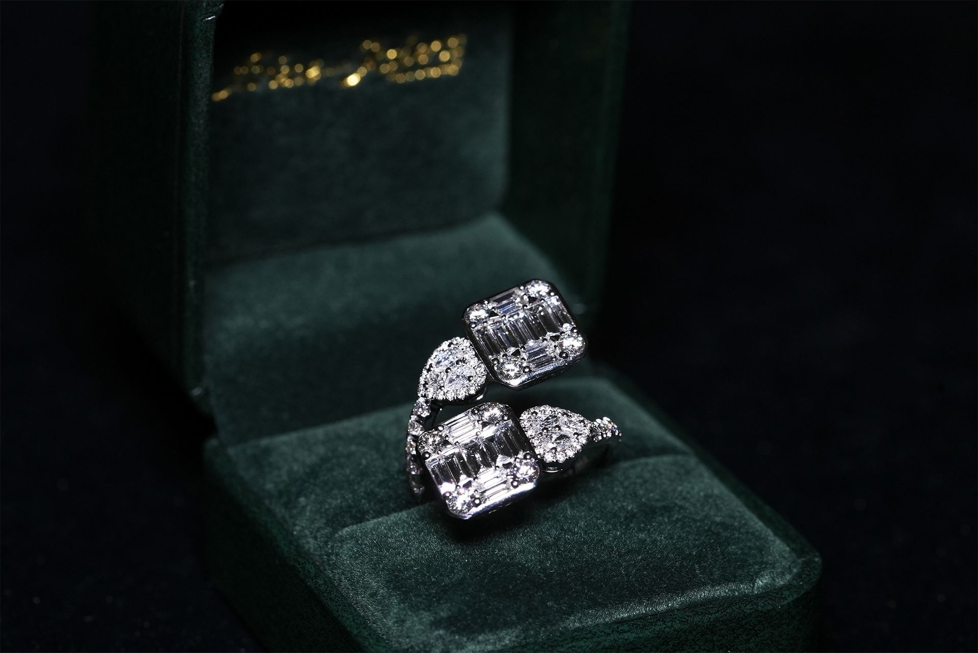 A diamond engagement ring and matching band in a green ring box